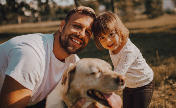 istock Father and daughter walking together with dog 1253088339