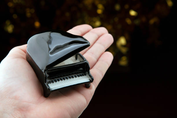 istock image of black piano hand dark background 1253088422