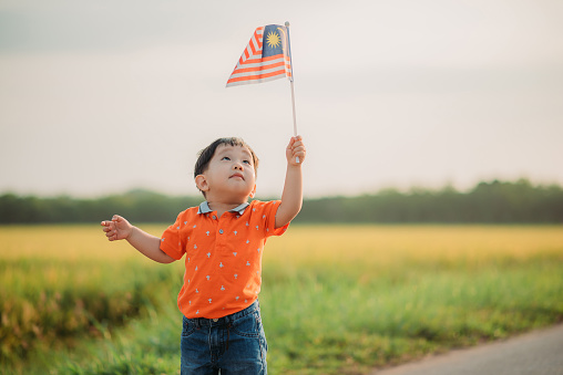 Raised up and looking on the flag. Celebrating Malaysia Independence Day \