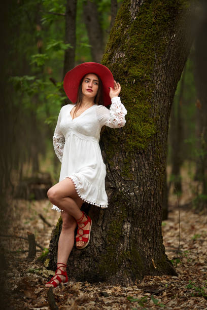 Gorgeous beauty model in summer dress posing outdoor in an oak forest