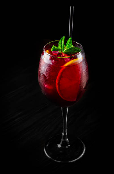 istock Cold sangria wine in a wine glass with reflection on black background 1253098543