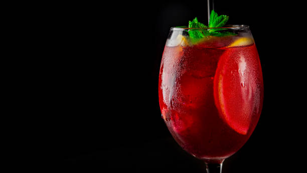 istock Cold sangria wine in a wine glass with reflection on black background 1253098556