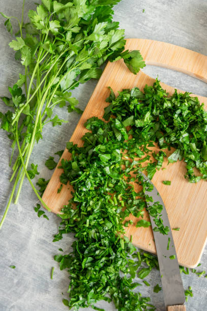 istock Cooking with greenery, fresh raw parsley and garlic on kitchen table 1253099215