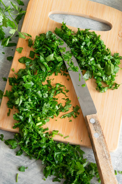 istock Cooking with greenery, fresh raw parsley and garlic on kitchen table 1253099219