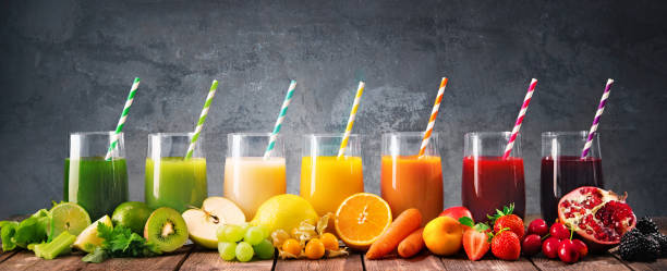 Assortment of fresh fruits and vegetables juices in rainbow colors Panoramic food background with assortment of fresh fruits and vegetables juices in rainbow colors juice drink stock pictures, royalty-free photos & images