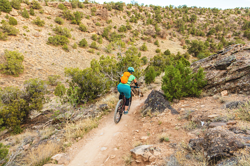 Mature Adult Female Adult Female Mountain Biking in Western Colorado Desert Arid Climate late Evening (Shot with Canon 5DS 50.6mp photos professionally retouched - Lightroom / Photoshop - original size 5792 x 8688 downsampled as needed for clarity and select focus used for dramatic effect)