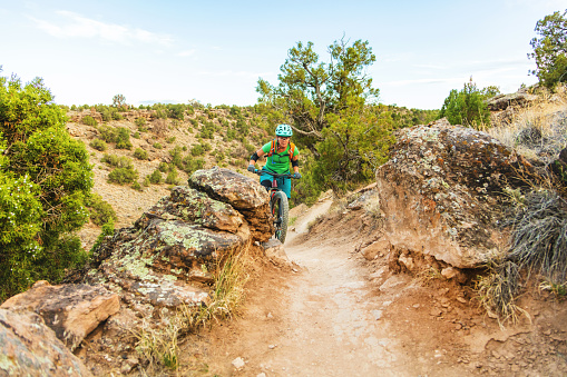Mature Adult Female Adult Female Mountain Biking in Western Colorado Desert Arid Climate late Evening (Shot with Canon 5DS 50.6mp photos professionally retouched - Lightroom / Photoshop - original size 5792 x 8688 downsampled as needed for clarity and select focus used for dramatic effect)