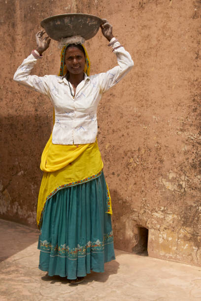 Female construction workers Female laborers transporting water and plaster in bowls carried on the head during the restoration of a palace inside Amber Fort in Jaipur, Rajasthan, India. History of Women In Construction stock pictures, royalty-free photos & images