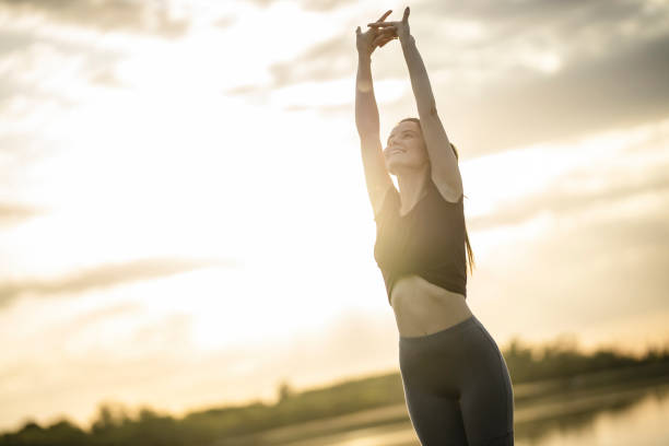 istock Young sporty woman stretching on sunset 1253108406