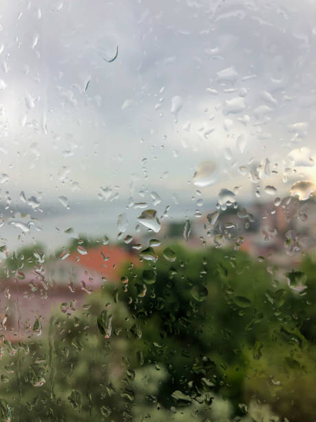 istock rain drops on a window pane against city view 1253114952