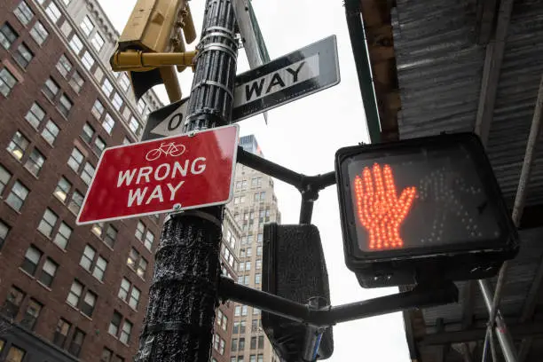 Photo of Red Traffic stop sign, Wrong Way and One Way sign in an urban area.