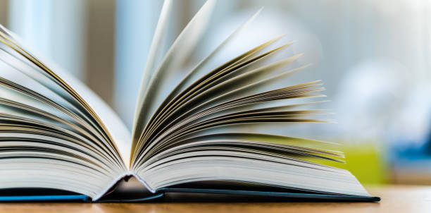 istock Open book lying on the table in the library 1253116717