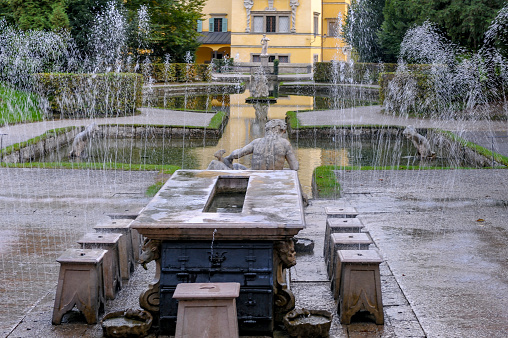 Marble table and seats are funny trick fountains in the west garden of the Hellbrunn Palace, designed by the Prince Archbishop of Salzburg to entertain his guests. The tourists are supprised and splashed by the trick fountain.