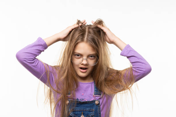 istock Long-haired girl scratches her head with her hands 1253118483