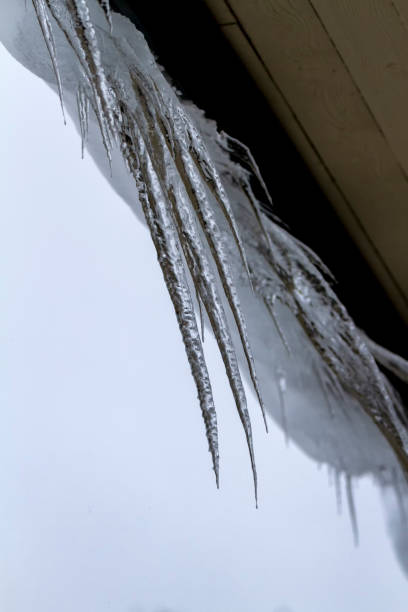 istock Large icicles hanging from the roof 1253119805