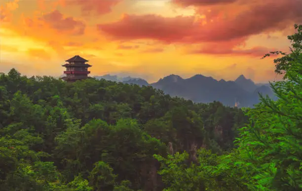 Traditional chinese architecture pagoda temple building on top of a mountain peak overlooking the stunning rock  pillars of the Tianzi mountain range, Avatar mountains nature park, Zhangjiajie, China