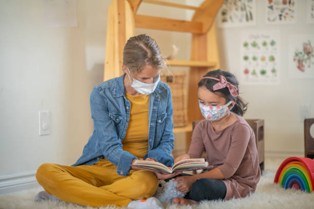 Home daycare with masks Little girl wearing a mask at a home daycare setting. montessori education photos stock pictures, royalty-free photos & images