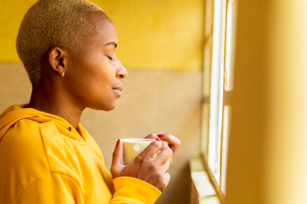 istock Woman in quarantine for COVID-19 drinking coffee and using her creativity with the color yellow 1253125414
