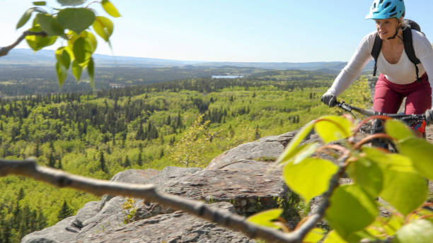 istock Female mountain e-biker rides along mountain ridge 1253128430