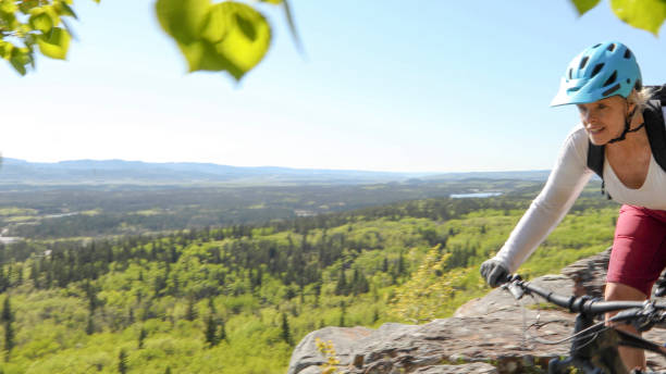 istock Female mountain e-biker rides along mountain ridge 1253129151