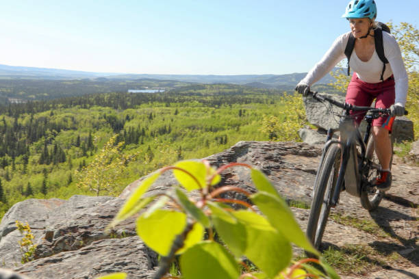istock Female mountain e-biker rides along mountain ridge 1253129298