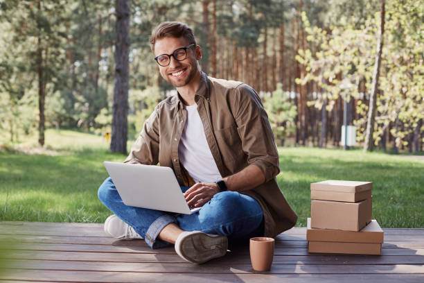 istock Young cheerful male working in nature environment 1253129539