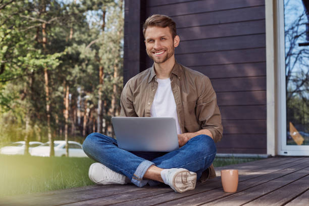istock Handsome young man with a laptop outdoors 1253129633