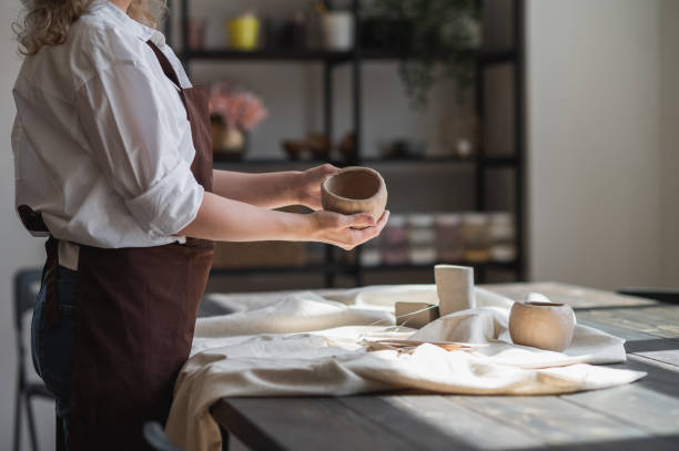 istock Professional female potter shaping and carving parts pottery workshop, studio. Crafting, artwork and handmade concept 1253130400