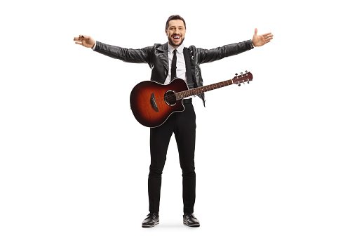 Full length portrait of a male musician with an electric guitar spreading arms isolated on white background