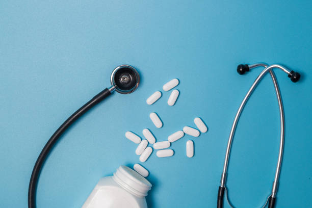 istock Top view of pills in bottle pack, stethoscope on blue background 1253133269