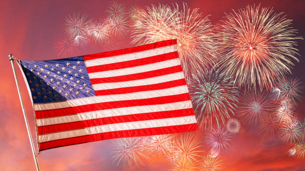istock Beautiful US Flag Flying High in the Sunset Sky With Fireworks 1253134503