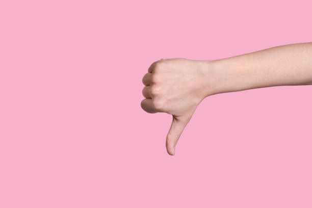 Close up thumb down caucasian hand gesture. Everything is bad. Close up thumb down caucasian hand gesture. Everything is bad. Pink background. thumb down stock pictures, royalty-free photos & images