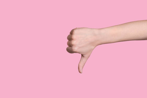 Close up thumb down caucasian hand gesture. Everything is bad. Close up thumb down caucasian hand gesture. Everything is bad. Pink background. thumbs down stock pictures, royalty-free photos & images