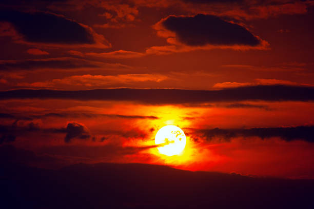 coucher du soleil mystique avec le ciel rouge et le grand cadran solaire - dramatic sky dusk night sustainable resources photos et images de collection