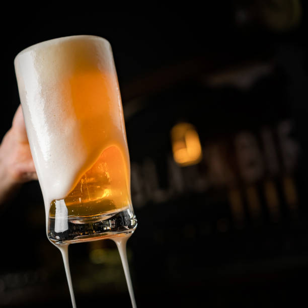 istock hand with beer mug, toasting in celebration 1253144464