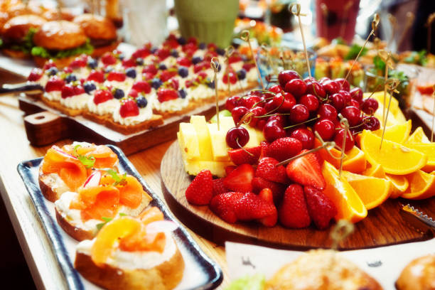 istock Fruits, fish snacks and dessert on catering table, toned 1253153568