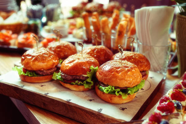 istock Burgers and another food on restaurant table, toned 1253153571