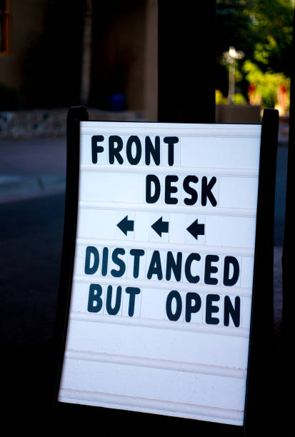 istock Pandemic Reopening Sign: FRONT DESK, DISTANCED BUT OPEN 1253153925