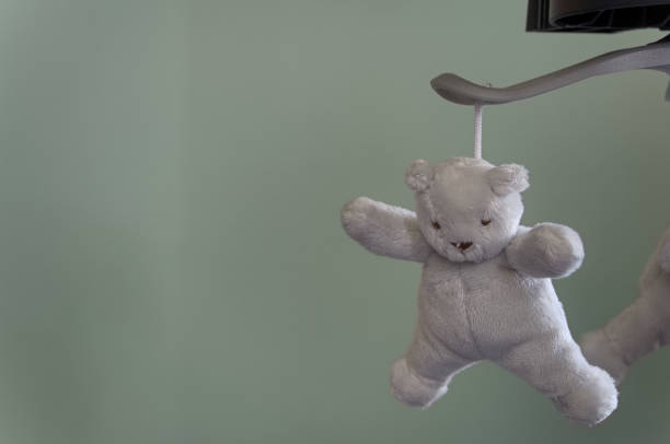 istock A plush teddy bear hanging from a mobile 1253157453