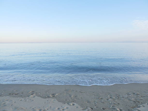 Footprinted sandy beach and sky with horizon and gradation