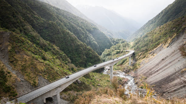 istock Highway winding through green mountain valley 1253162631