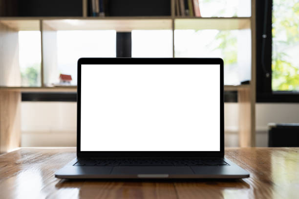 istock Laptop computer mockup and blank screen on wooden table with morning light. 1253164254