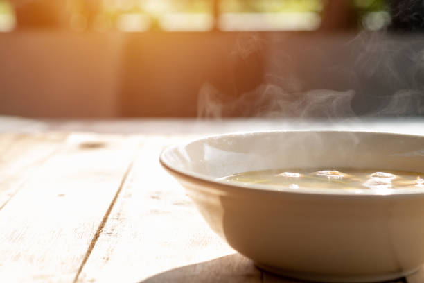 tom yum o sopa de champiñones, que tiene vapor caliente en un tazón, colocado en una mesa en el sol de la mañana - tom tom yum meal soup fotografías e imágenes de stock