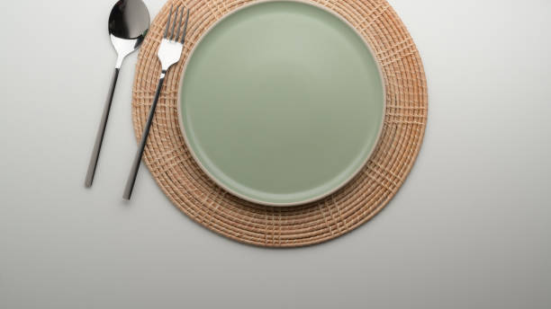 istock Dinning table with mock-up turquoise ceramic plate and silverware on placemat 1253171369