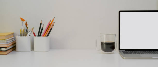 istock Designer worktable with copy space, mock-up laptop, stationery, painting tools, books and coffee cup 1253171417