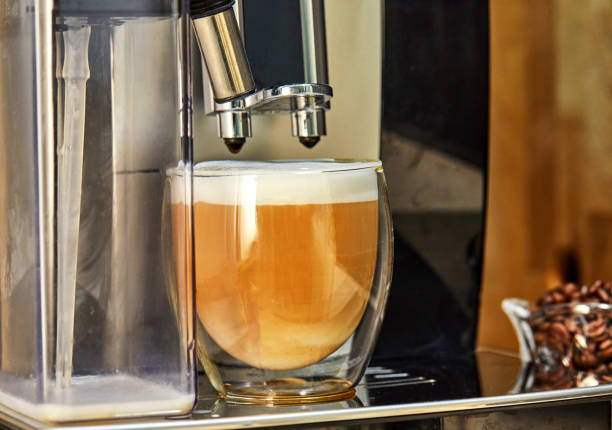 istock Coffee machine makes cappuccino coffee in a transparent cup 1253182405