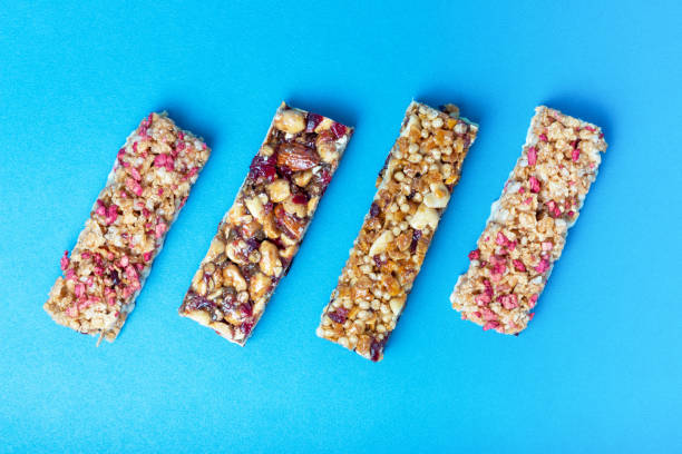 istock Four protein bars with cereals isolated on blue background, a copy of the space 1253182407
