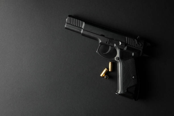 istock Pistol and traumatic bullets on black background. Self defense weapon 1253189440