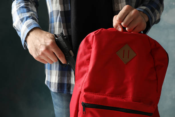 istock Man takes out a gun from backpack, close up. Terrorism 1253189511
