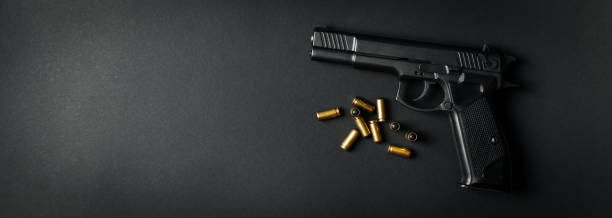 istock Pistol and traumatic bullets on black background. Self defense weapon 1253189625